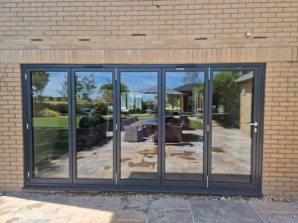 Schüco aluminium doors in a five panel folding design to a new brick extension